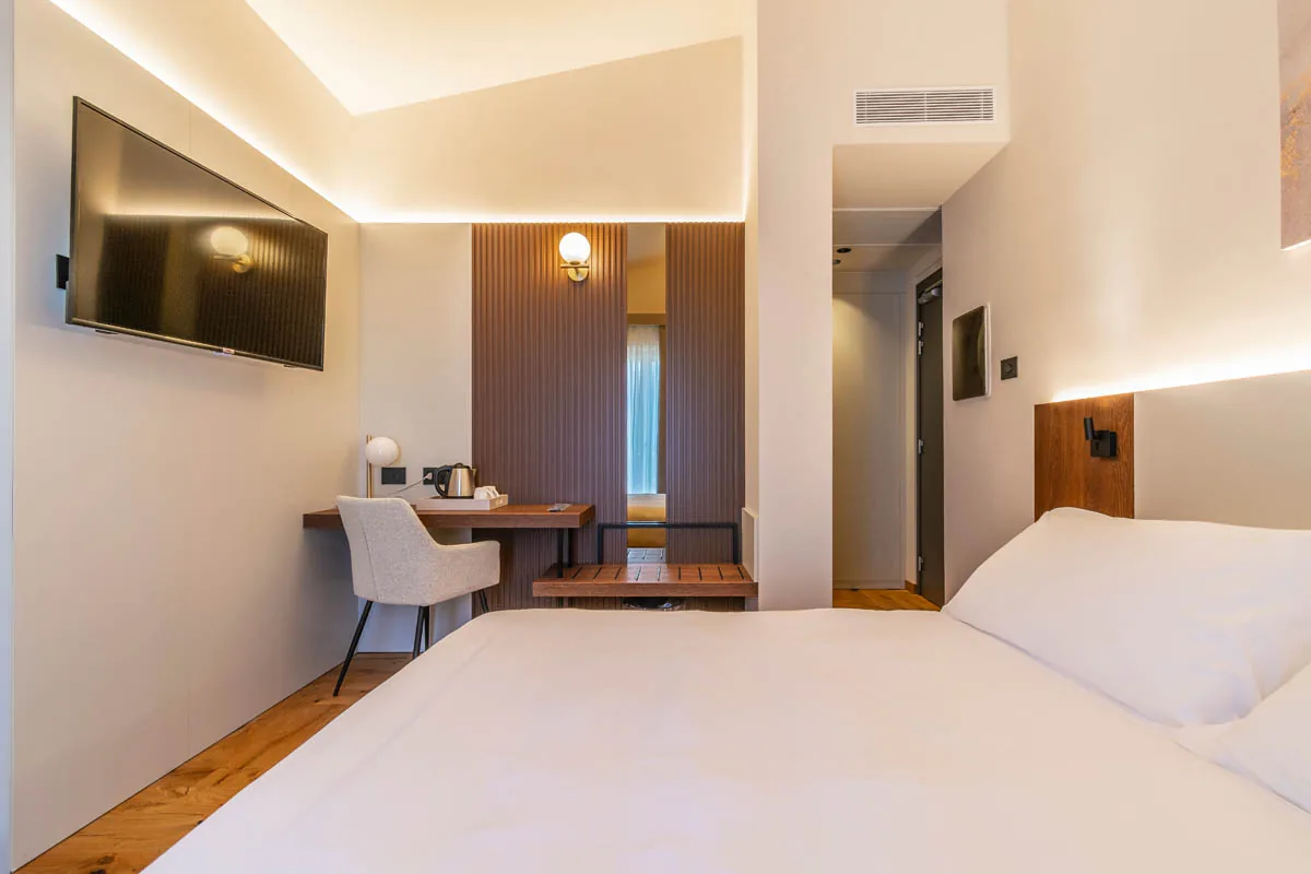 camera Deluxe con letto matrimoniale in primo piano, tv a parete e scrivania