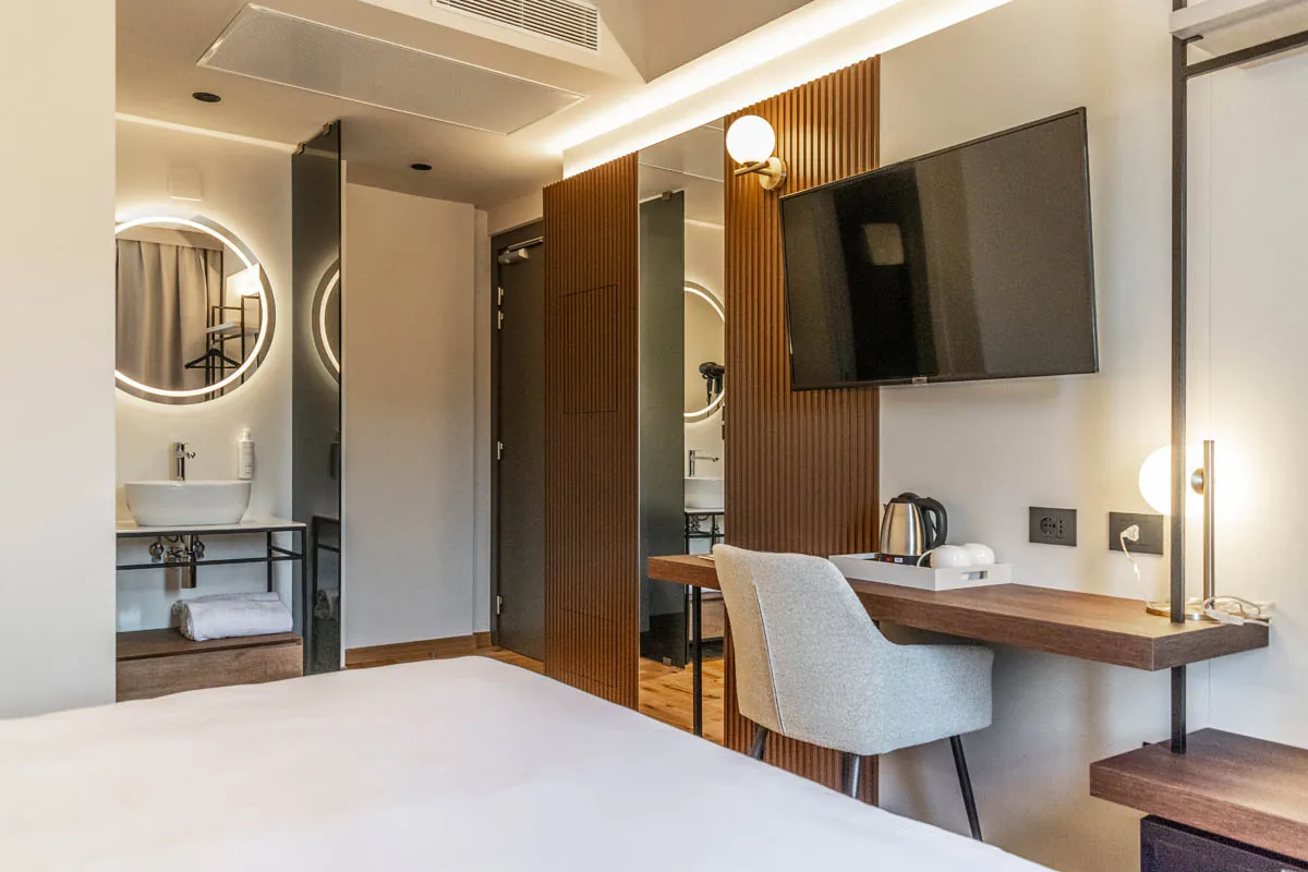 camera Superior con letto matrimoniale, scrivania sospesa, televisore e lavabo a vista