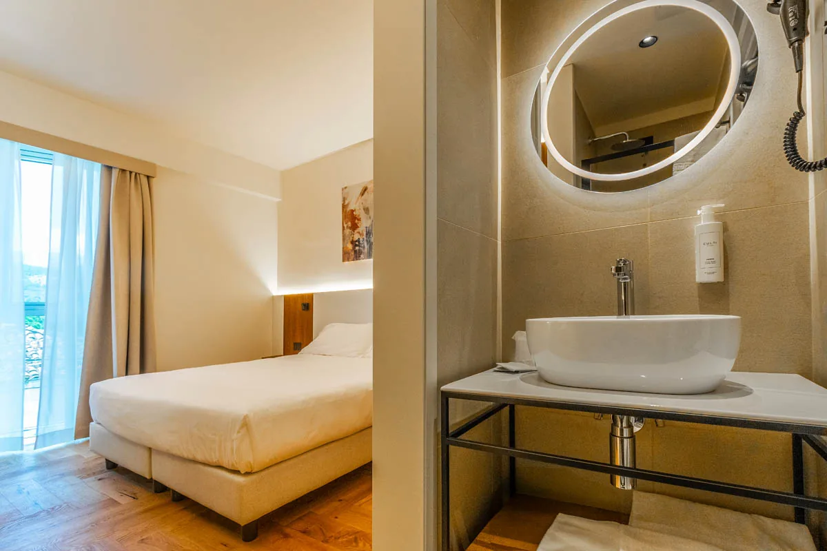 camera Superior con letto matrimoniale e bagno a vista con lavabo e specchio rotondo