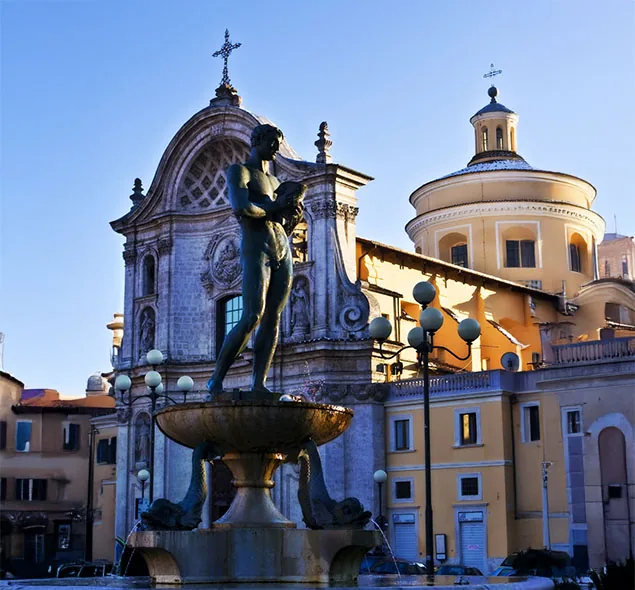 fontana monumentale con statue davanti a una chiesa e a un edificio con cupola